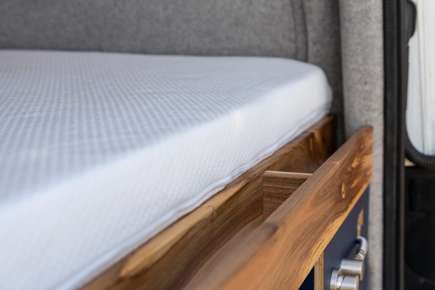 Ablage aus Nussbaumholz hinter dem Querbett im Sprinter L3H2 Ausbau