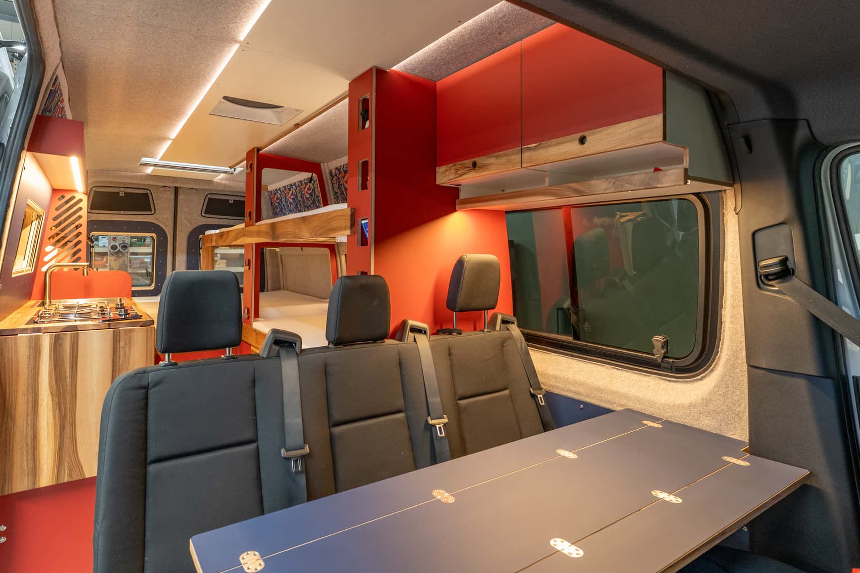 Blick in den Sprinter L3H2 Ausbau vom Beifahrersitz mit Küchenzeile und Stockbetten